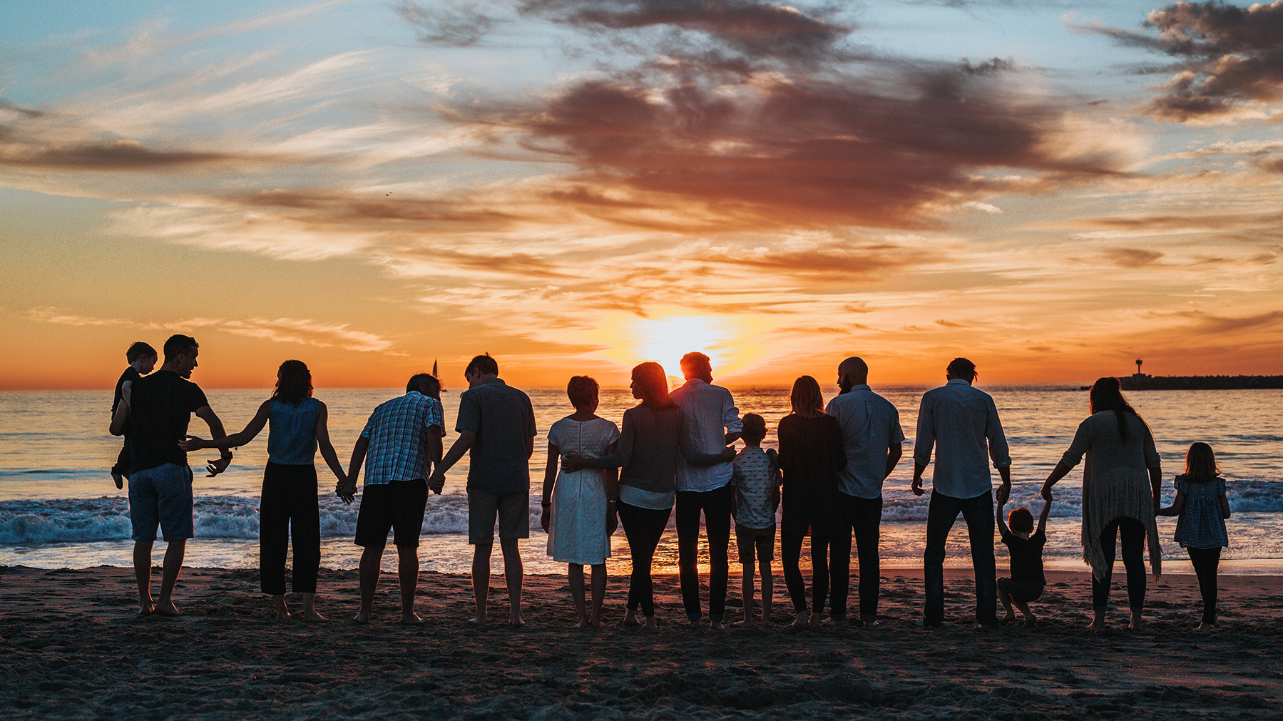 Famille sur une plage avec soleil couchant
